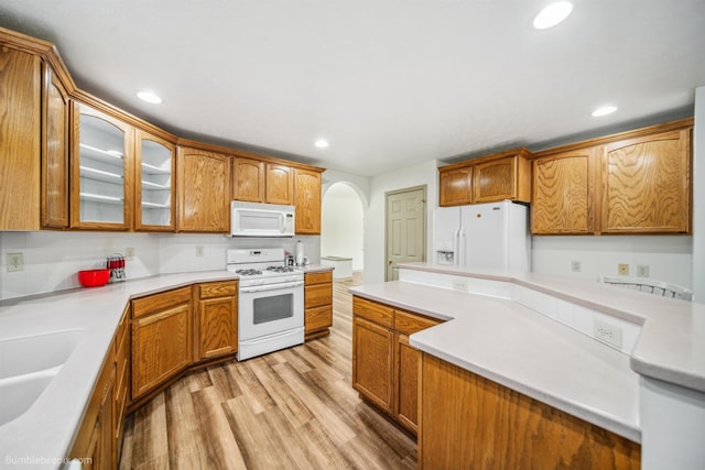706 S Shelley Lake Ln, Veradale, WA 99037 - kitchen with white appliances, arched walkways, glass insert cabinets, light wood-style floors, and light countertops