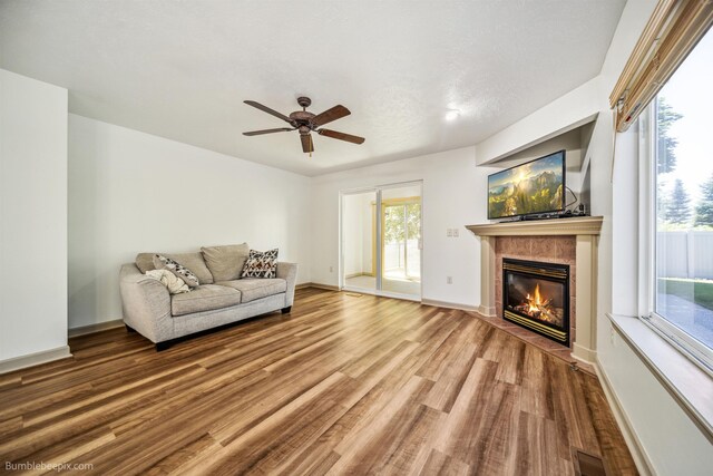 706 S Shelley Lake Ln, Veradale, WA 99037 - unfurnished living room with wood finished floors, a ceiling fan, and a fireplace