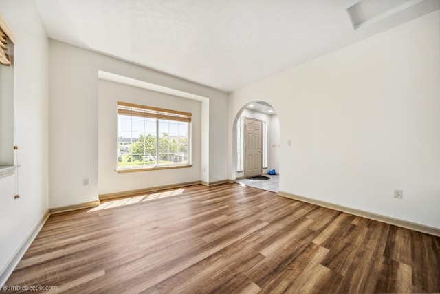 706 S Shelley Lake Ln, Veradale, WA 99037 - spare room featuring arched walkways and wood finished floors
