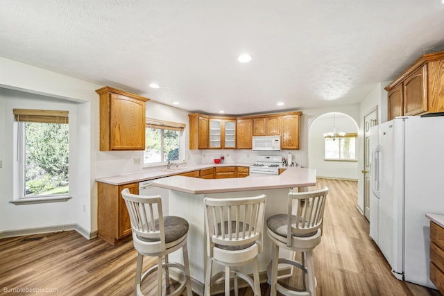 706 S Shelley Lake Ln, Veradale, WA 99037 - kitchen with white appliances, light wood-style flooring, light countertops, a center island, and recessed lighting
