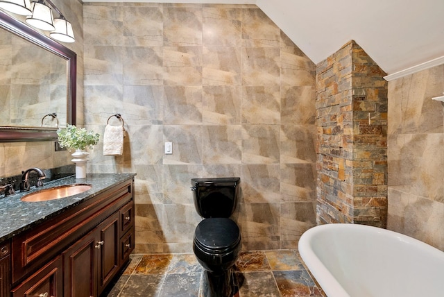 1420 W Main Ave, Spokane, WA 99201 - bathroom with tile walls, a freestanding tub, vanity, vaulted ceiling, and stone finish floors
