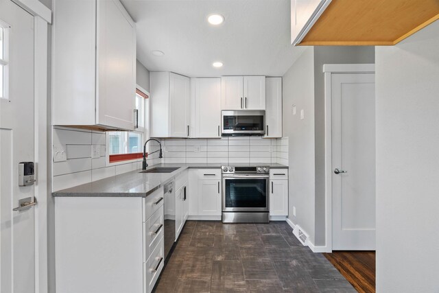 3218 E 24th Ave, Spokane, WA 99223 - kitchen featuring stainless steel appliances, recessed lighting, white cabinets, tasteful backsplash, and dark stone counters