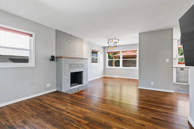 3218 E 24th Ave, Spokane, WA 99223 - unfurnished living room featuring wood finished floors, a chandelier, and a fireplace