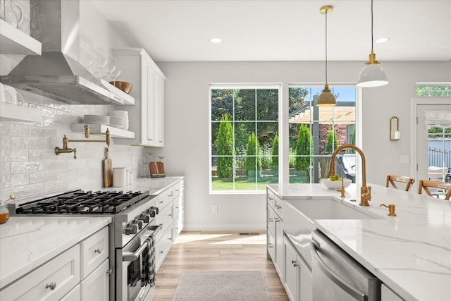 4620 E 43rd Ave, Spokane, WA 99223 - kitchen featuring appliances with stainless steel finishes, wall chimney exhaust hood, white cabinets, plenty of natural light, and recessed lighting