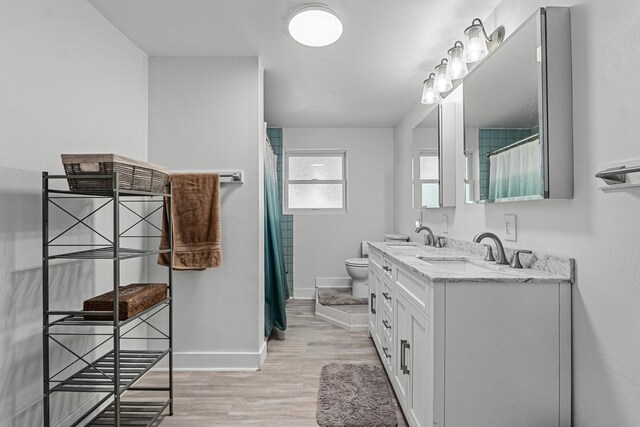 4217 E 22nd Ave, Spokane, WA 99223 - bathroom featuring double vanity, wood finished floors, and curtained shower