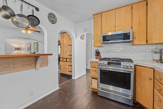 4217 E 22nd Ave, Spokane, WA 99223 - kitchen featuring appliances with stainless steel finishes, tasteful backsplash, ceiling fan, light countertops, and dark wood-type flooring