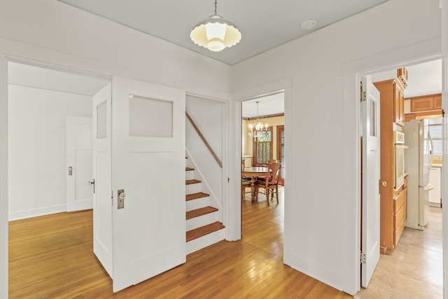 1107 W 19th Ave, Spokane, WA 99203 - hallway with a chandelier, stairway, and light wood-style floors