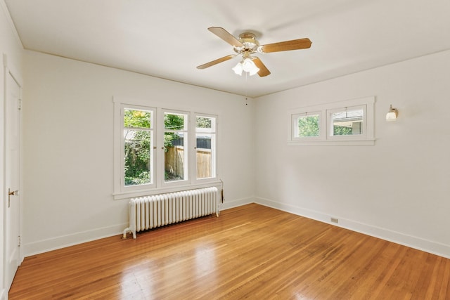 1107 W 19th Ave, Spokane, WA 99203 - unfurnished room with radiator heating unit, plenty of natural light, and light wood-style floors