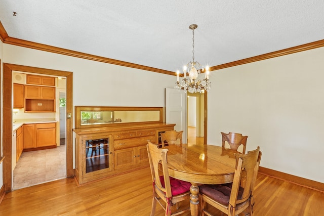 1107 W 19th Ave, Spokane, WA 99203 - dining area with crown molding, a chandelier, light wood-style floors, and wine cooler