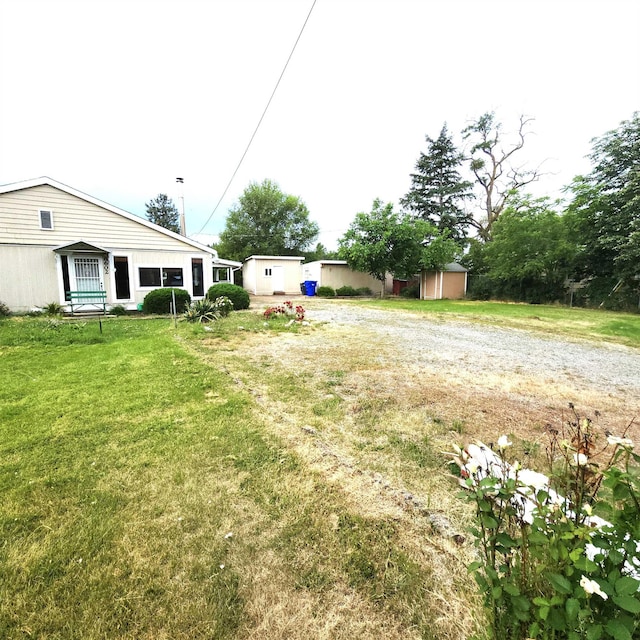 8602 E E Harrington Ave, Spokane Valley, WA 99212 - view of green lawn featuring a storage unit and dirt driveway