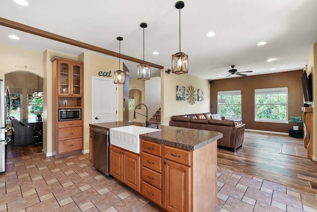 5857 Little Sandy Loop Rd, Nine Mile Falls, WA 99026 - kitchen with stainless steel appliances, arched walkways, a ceiling fan, a kitchen island with sink, and open floor plan