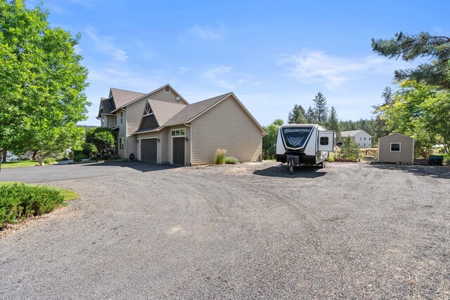 5857 Little Sandy Loop Rd, Nine Mile Falls, WA 99026 - view of front of home featuring an attached garage, driveway, and a storage unit
