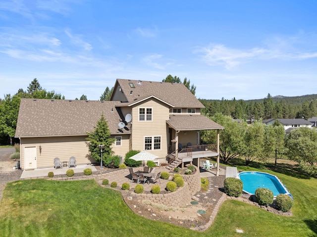 5857 Little Sandy Loop Rd, Nine Mile Falls, WA 99026 - back of property featuring a wooden deck, a patio area, a yard, a shingled roof, and an outdoor pool