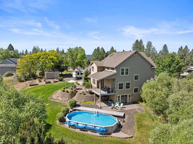 5857 Little Sandy Loop Rd, Nine Mile Falls, WA 99026 - swimming pool featuring a deck, a patio area, a lawn, and a storage unit