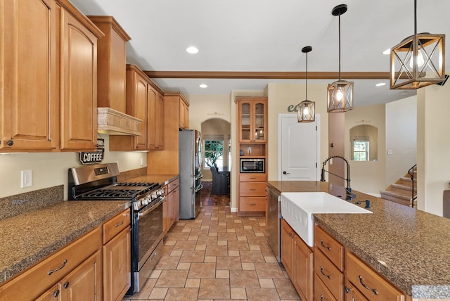 5857 Little Sandy Loop Rd, Nine Mile Falls, WA 99026 - kitchen with stainless steel appliances, arched walkways, stone finish flooring, brown cabinetry, and recessed lighting