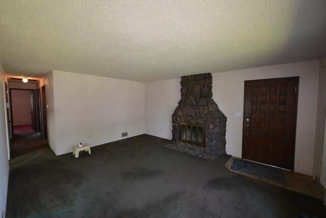7516 E Baldwin Ave, Spokane Valley, WA 99212 - unfurnished living room with carpet floors, a textured ceiling, and a stone fireplace