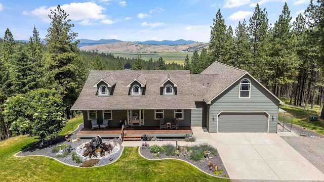 19918 E Pheasant Dr, Greenacres, WA 99016 - cape cod-style house featuring a front lawn, concrete driveway, a mountain view, a porch, and a garage