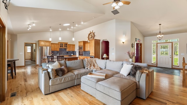 19918 E Pheasant Dr, Greenacres, WA 99016 - living room with high vaulted ceiling, light wood finished floors, ceiling fan, a chandelier, and arched walkways