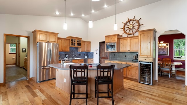 19918 E Pheasant Dr, Greenacres, WA 99016 - kitchen featuring stainless steel appliances, beverage cooler, a center island with sink, a breakfast bar, and light wood-type flooring