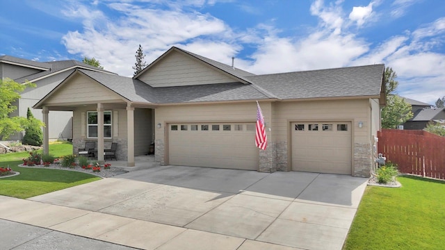 2204 S Lloyd Ct, Spokane, WA 99223 - view of front of house with a garage, stone siding, covered porch, and driveway