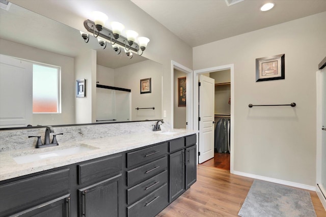 2204 S Lloyd Ct, Spokane, WA 99223 - full bathroom featuring double vanity, wood finished floors, a shower, a walk in closet, and recessed lighting