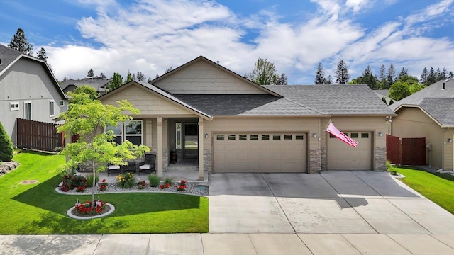 2204 S Lloyd Ct, Spokane, WA 99223 - view of front facade featuring a garage, concrete driveway, roof with shingles, and stone siding