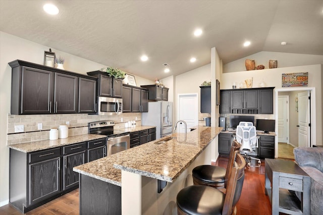 2204 S Lloyd Ct, Spokane, WA 99223 - kitchen with appliances with stainless steel finishes, vaulted ceiling, a breakfast bar, dark wood finished floors, and decorative backsplash