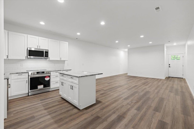 2236 E 4th Ave, Spokane, WA 99202 - kitchen featuring appliances with stainless steel finishes, white cabinetry, wood finished floors, recessed lighting, and backsplash