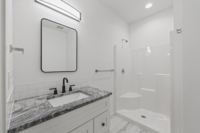 2236 E 4th Ave, Spokane, WA 99202 - full bathroom with vanity, marble look tiles, a shower, and recessed lighting