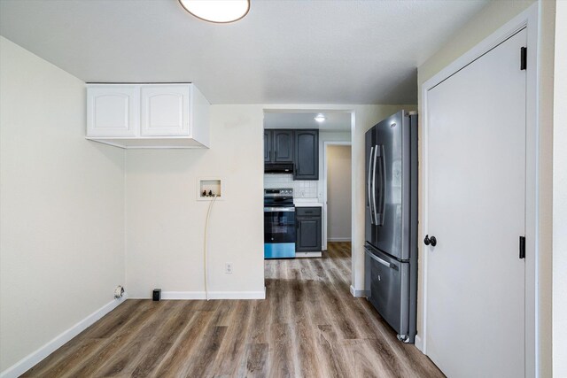 1541 Thompson Rd, Elk, WA 99009 - kitchen with stainless steel appliances, extractor fan, wood finished floors, decorative backsplash, and white cabinetry