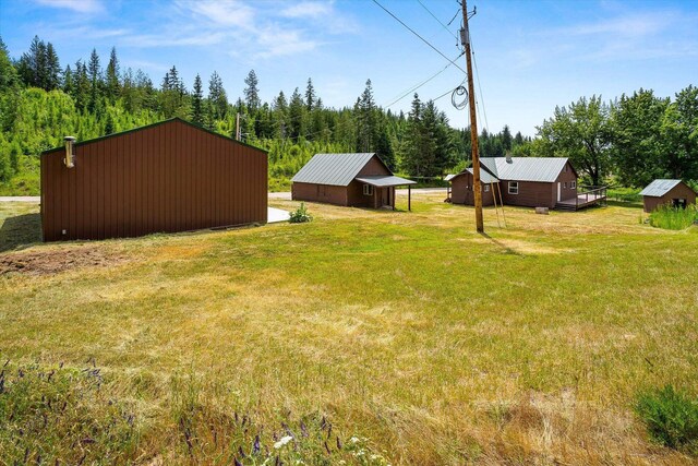 1541 Thompson Rd, Elk, WA 99009 - view of grassy yard featuring an outdoor structure and a wooded view