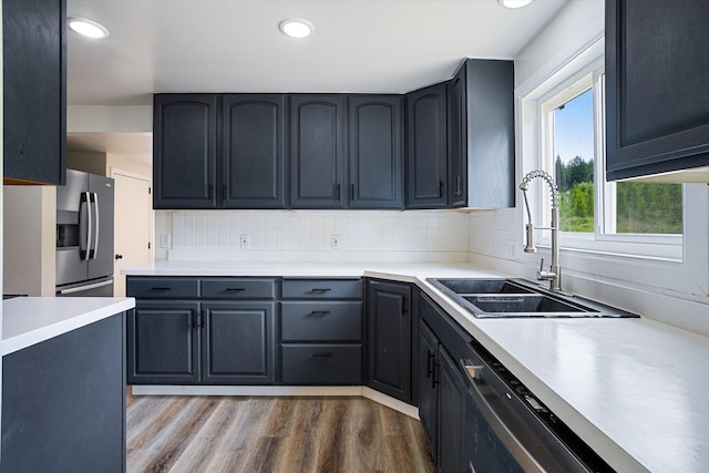 1541 Thompson Rd, Elk, WA 99009 - kitchen with stainless steel fridge, wood finished floors, tasteful backsplash, light countertops, and recessed lighting