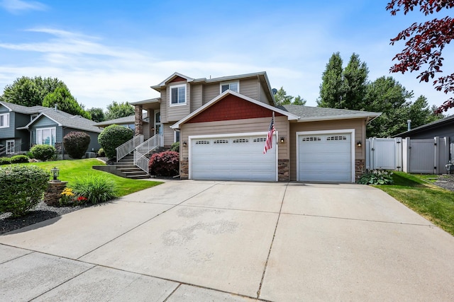 1308 S Drummond Rd, Spokane Valley, WA 99016 - view of front of property featuring stone siding, an attached garage, concrete driveway, and a gate