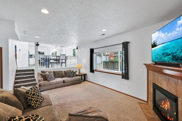 1308 S Drummond Rd, Spokane Valley, WA 99016 - living area featuring carpet, a tile fireplace, stairs, recessed lighting, and a textured ceiling