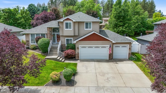 1308 S Drummond Rd, Spokane Valley, WA 99016 - tri-level home with a garage, driveway, a shingled roof, and stone siding