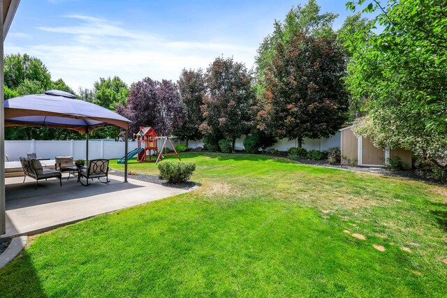 1308 S Drummond Rd, Spokane Valley, WA 99016 - fenced backyard featuring a playground, a patio, a gazebo, and a storage unit