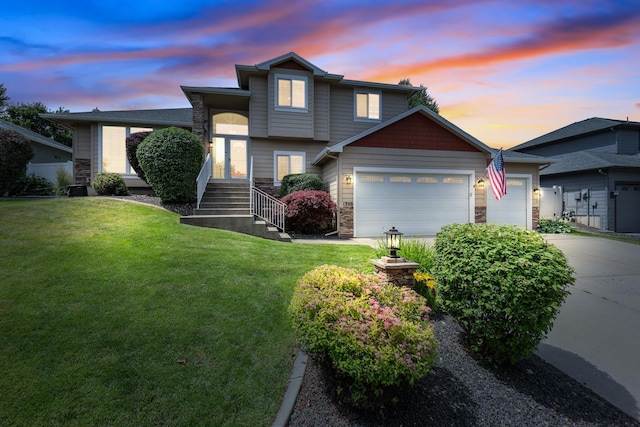 1308 S Drummond Rd, Spokane Valley, WA 99016 - tri-level home featuring stone siding, a garage, driveway, and a yard