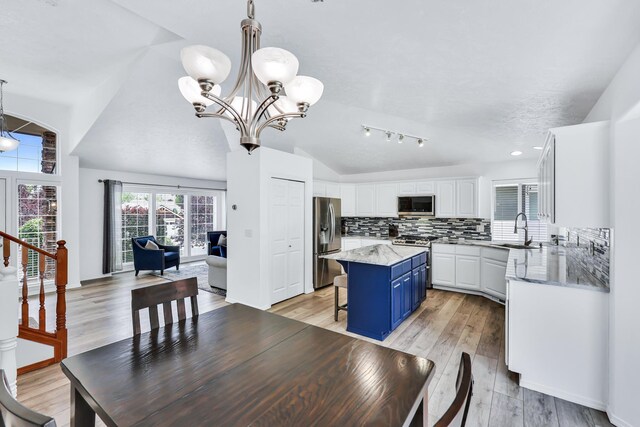 1308 S Drummond Rd, Spokane Valley, WA 99016 - dining room with vaulted ceiling, a chandelier, and light wood-style flooring