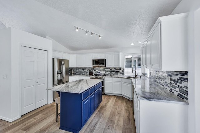 1308 S Drummond Rd, Spokane Valley, WA 99016 - kitchen featuring stainless steel appliances, blue cabinetry, white cabinetry, a textured ceiling, and a center island