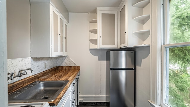 1622 W 10th Ave, Spokane, WA 99204 - kitchen with freestanding refrigerator, open shelves, white cabinetry, and healthy amount of natural light