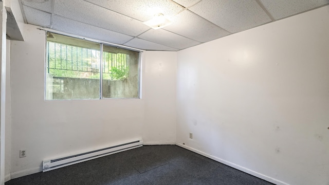 1622 W 10th Ave, Spokane, WA 99204 - unfurnished room featuring a baseboard radiator, a paneled ceiling, and dark carpet