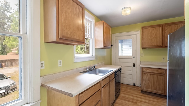 1622 W 10th Ave, Spokane, WA 99204 - kitchen featuring freestanding refrigerator, black dishwasher, light wood-style floors, light countertops, and healthy amount of natural light