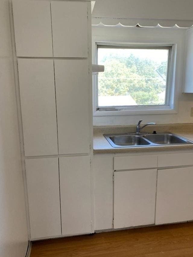 2526 W Sinto Ave, Spokane, WA 99201 - kitchen with white cabinetry, plenty of natural light, light countertops, and wood finished floors