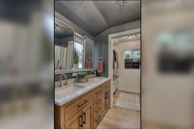 33348 Lakeview Ln, Valley, WA 99181 - bathroom with double vanity, lofted ceiling, wood finished floors, and a textured ceiling