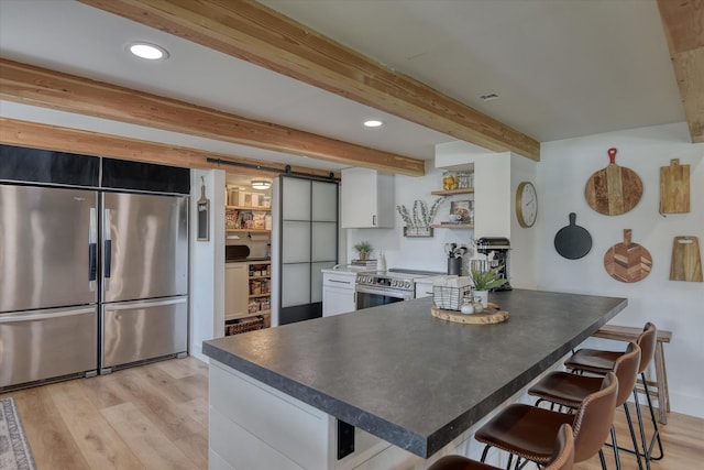 33348 Lakeview Ln, Valley, WA 99181 - kitchen with stainless steel appliances, a barn door, white cabinetry, open shelves, and light wood-style floors