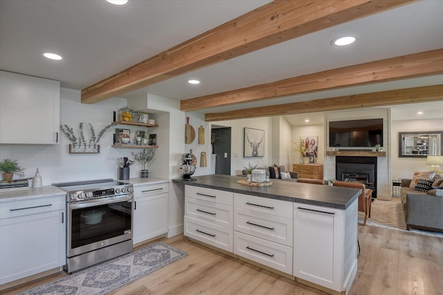 33348 Lakeview Ln, Valley, WA 99181 - kitchen with stainless steel range with electric stovetop, a peninsula, white cabinets, light wood finished floors, and a fireplace
