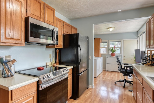 4526 N Walnut St, Spokane, WA 99205 - kitchen with stainless steel appliances, washing machine and clothes dryer, light wood finished floors, light countertops, and an office area