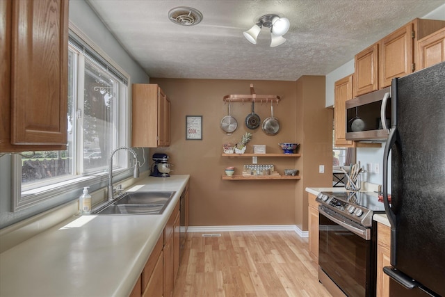 4526 N Walnut St, Spokane, WA 99205 - kitchen with appliances with stainless steel finishes, light wood-type flooring, light countertops, a textured ceiling, and open shelves