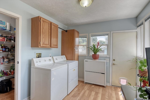 4526 N Walnut St, Spokane, WA 99205 - laundry area with washer and dryer, light wood-style flooring, cabinet space, and a textured ceiling
