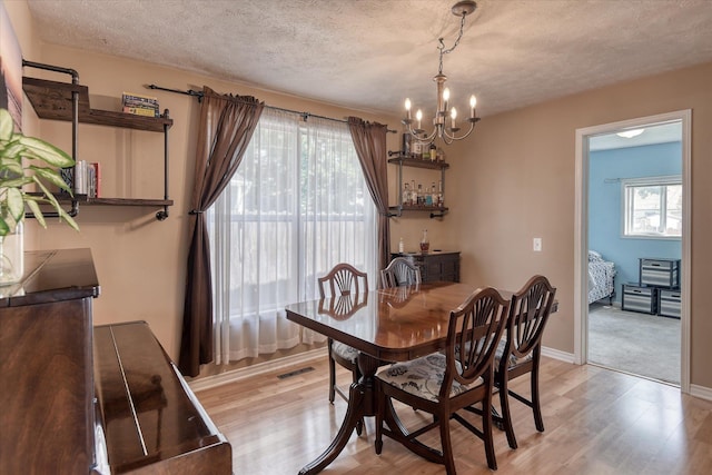 4526 N Walnut St, Spokane, WA 99205 - dining space featuring a chandelier, light wood-style flooring, and a textured ceiling